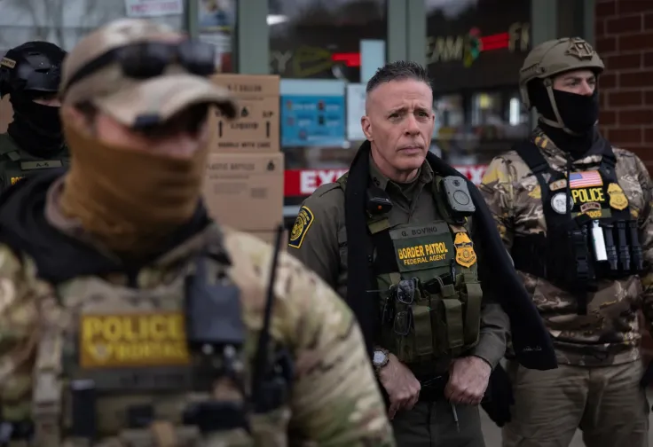 US Border Patrol official Gregory Bovino and a group of masked and armed immigration agents at a gas station in Minneapolis, January 13, in a photograph by Scott Olson via Getty Images.