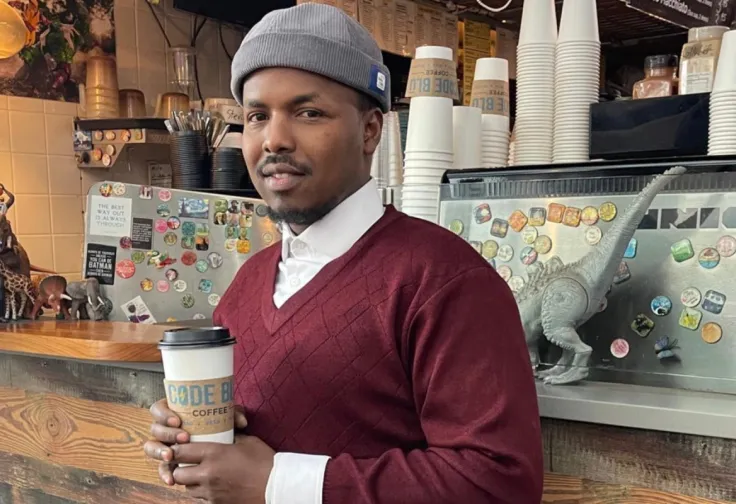 St. Paul resident Adam Abdullah holds a coffee cup inside the Code Blu coffee shop.